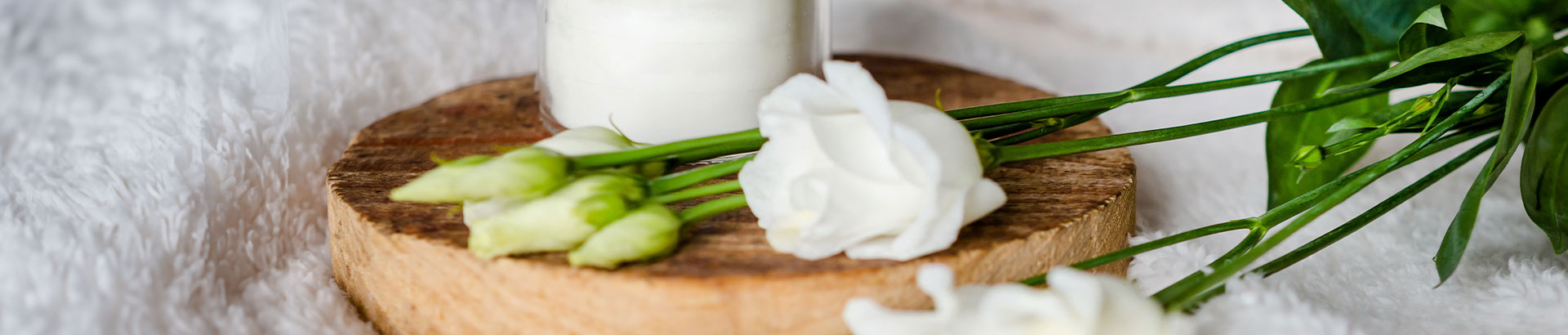 Neroli essential oil only needs a few drops with flowers laying across bed.